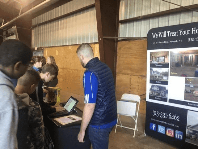 Marshall Exteriors, LLC contractor talking to people at the booth at the career carnival